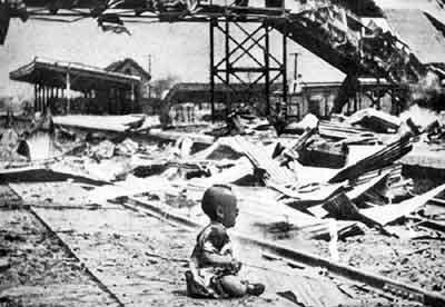 baby sitting alone in a rail track among destruction