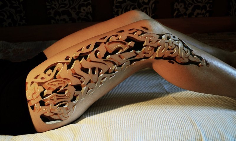 girl leg tattoo as carved wood art